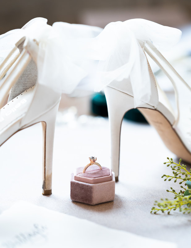 bride's high heel shoes with wedding ring
